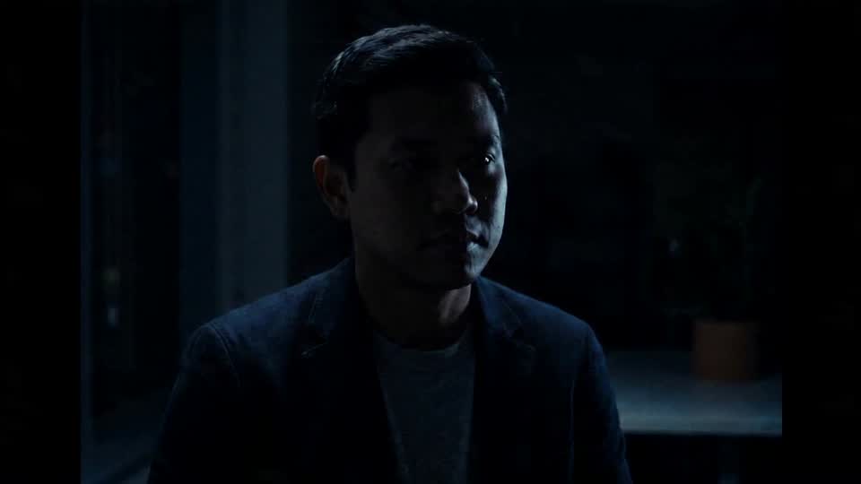 The glow of a phone lifting his face out of the dark, and a small real smile